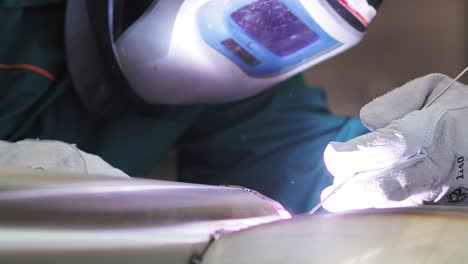 welder, using vig, tig, mig mag method to welding stainless steel parts, close up. the welder uses a mask to protect your eyes. argon welding of stainless steel sheet, parts. scene c.
