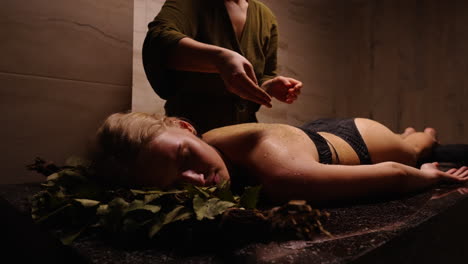 woman receiving traditional herbal back massage at a spa