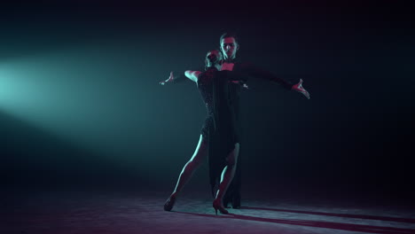 couple performing latin dance on stage. ballroom partners dancing indoors.