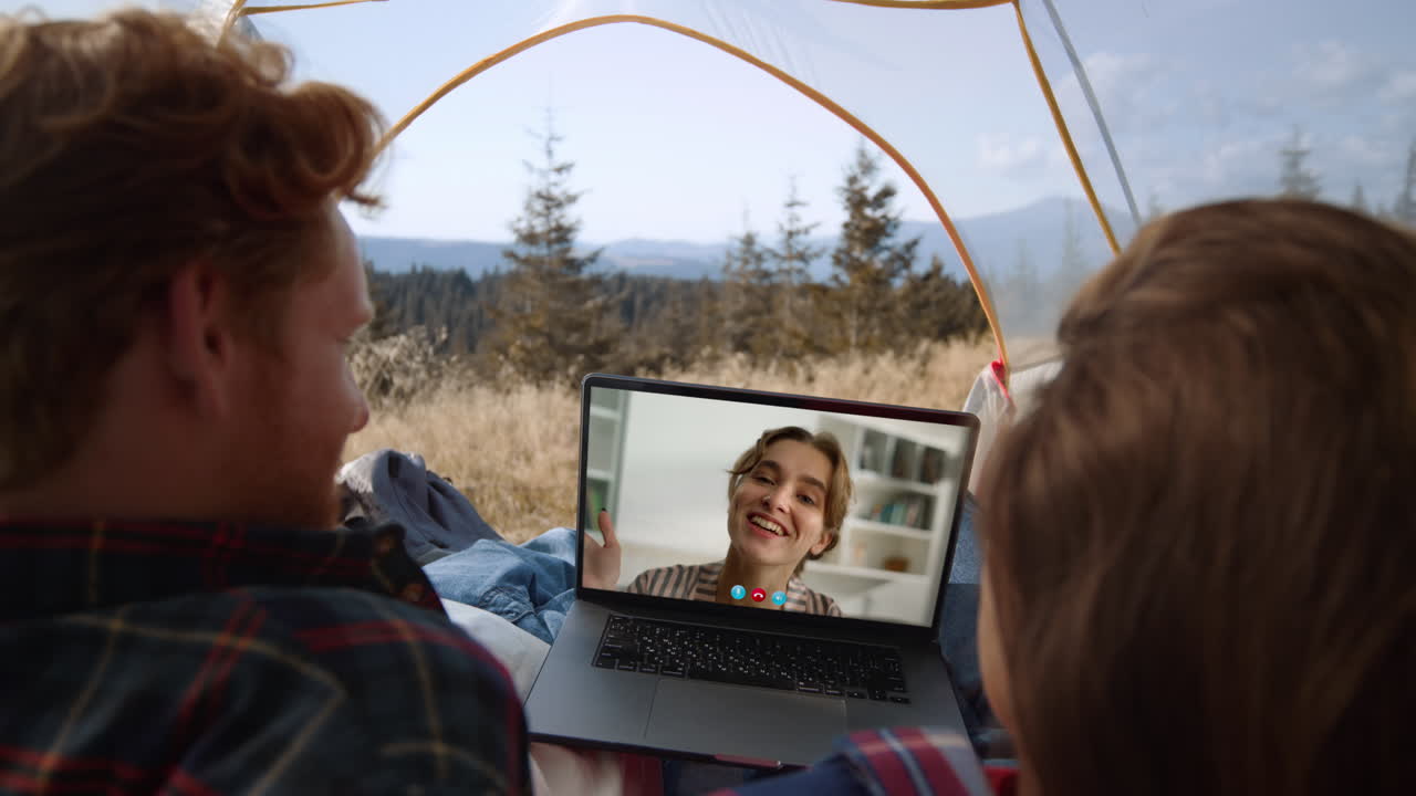 Carefree couple making conference call on hiking trip. Close up smiling girl