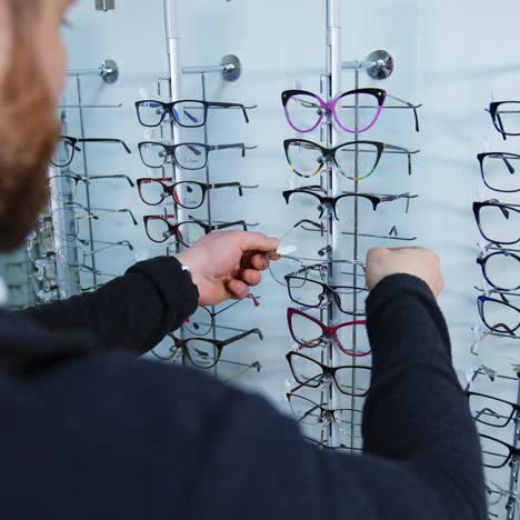 man shopping for glasses in store