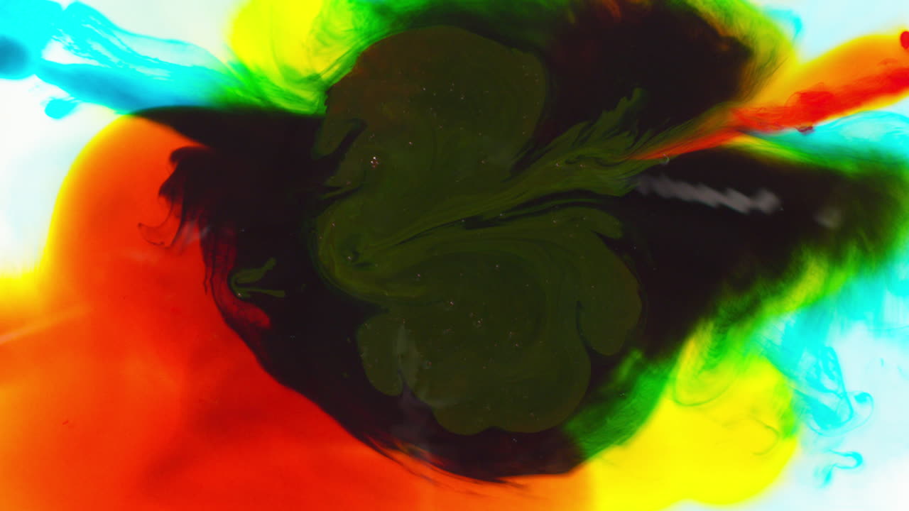 disparo aéreo de gotas de pintura o tinte multicolor que se mezclan en agua para crear un patrón colorido giratorio 2