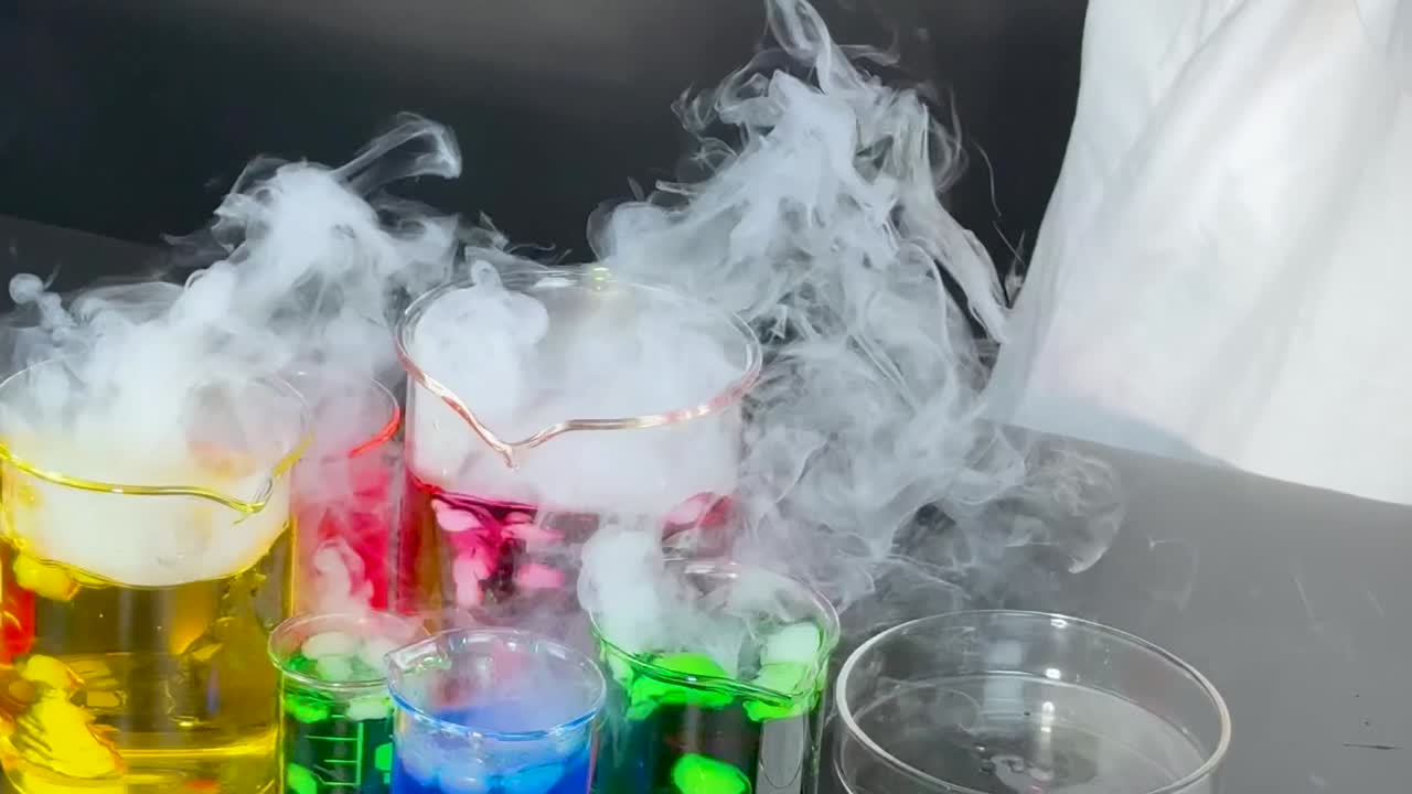 과학자 는 다채로운 액체 와 연기 를 사용 하여 실험 을 한다