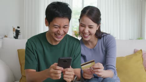 happy asian man and woman booking ticket online from retail store.