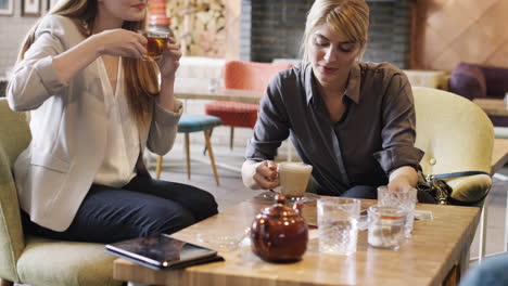 Kreative-Geschäftsfrauen-Treffen-Sich-Im-Café-Und-Schauen-Sich-Fotos-An