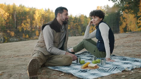 couple enjoying a picnic in autumn forest