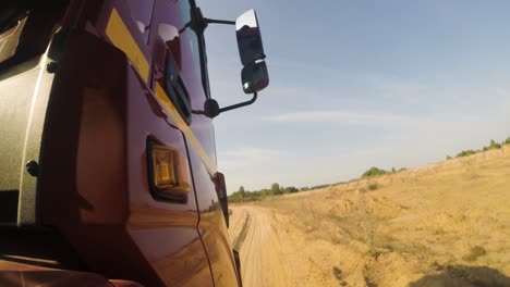 red truck driving on a dirt road through a quarry