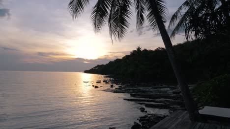 beautiful sunset or sunrise at beach with coconut or palm tree in thailand