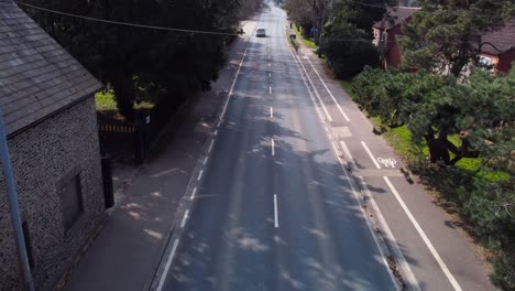 Empty-asphalt-road-on-the-plateau-between-green-fields,-aerial-view