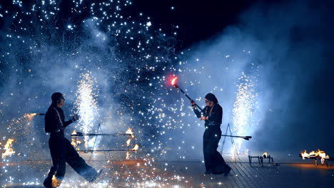 firework show performance at night. two male actors dance with props producing fireworks.