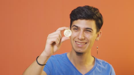 hombre sosteniendo bitcoin y mostrándolo.