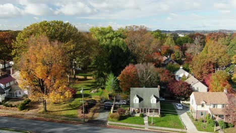 aerial of cute cape cod house and traditional homes along small town community in united states of america, usa