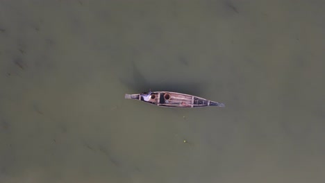 small traditional asian fishing boat seen from above, aerial drone zooming out