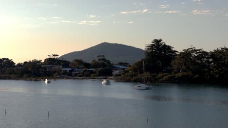 a-lake-with-boats-in-it-and-a-mountain-in-the-background-with-a-sky-line-above-it-and-a-few-clouds