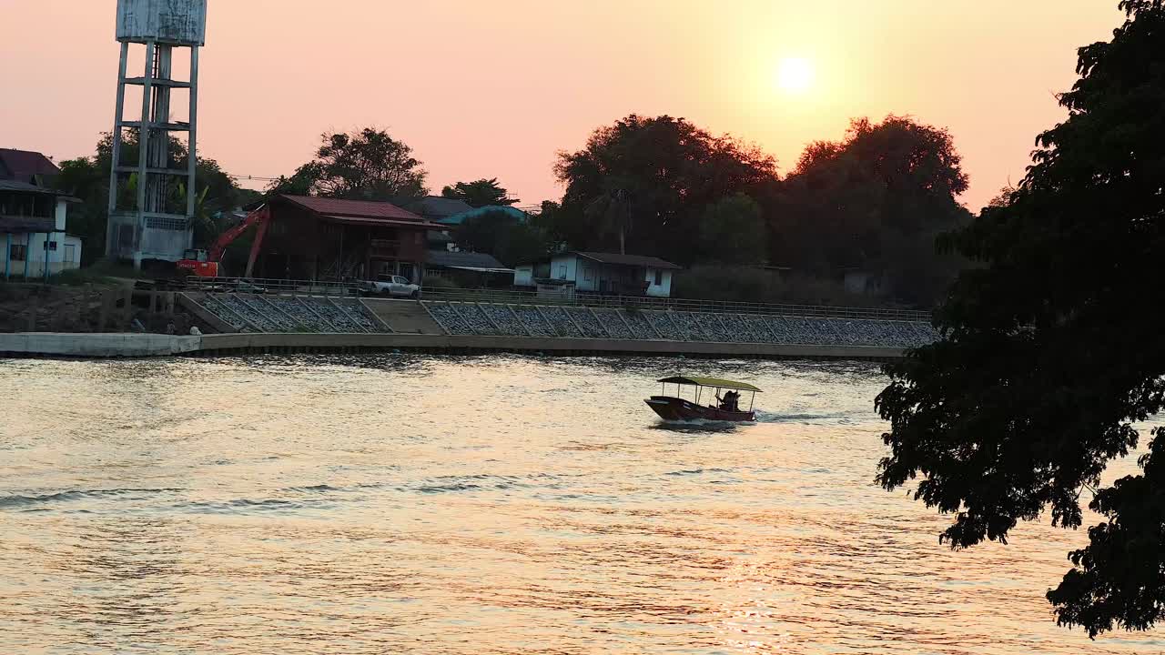 해가 지는 동안 강을 가로질러 움직이는 배