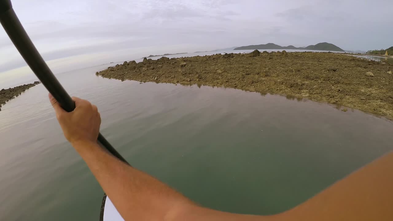imágenes pov de un paddle boarder remando a través de un estrecho arroyo durante la puesta de sol en koh samui