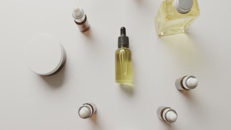 high angle view of cream tub and glass bottles with copy space on white background