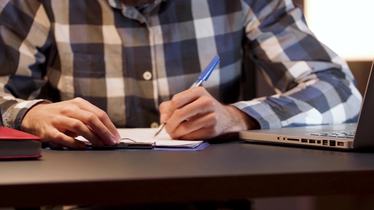Uomo che esamina e firma documenti a una scrivania