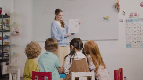 female teacher teaching letters of the alphabet to her pupils in a montessori school 3