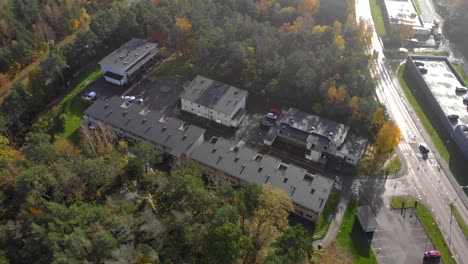 Aerial-view-over-residential-buildings-in-a-neighborhood-surrounded-by-a-tree-forest-autumn-color