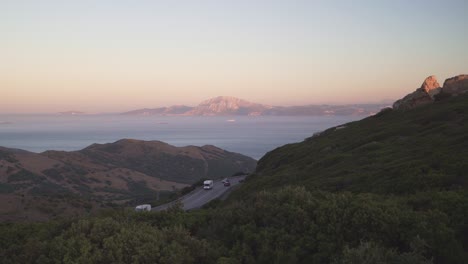 Blick-Auf-Die-Meerenge-Von-Gibraltar-Aus-Spanien-Mit-Der-Gebirgsstraße-Jebel-Musa-Mit-Wohnmobilen-Und-Autos-Und-Großen-Transportschiffen,-Die-Vom-Mittelmeer-Zum-Atlantischen-Ozean-Fahren