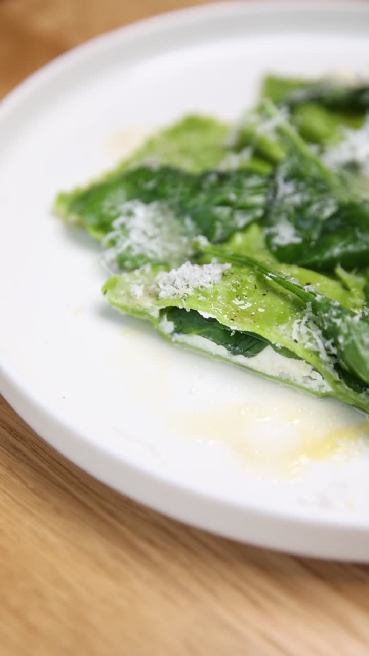Primo piano di pasta verde con parmigiano grattugiato