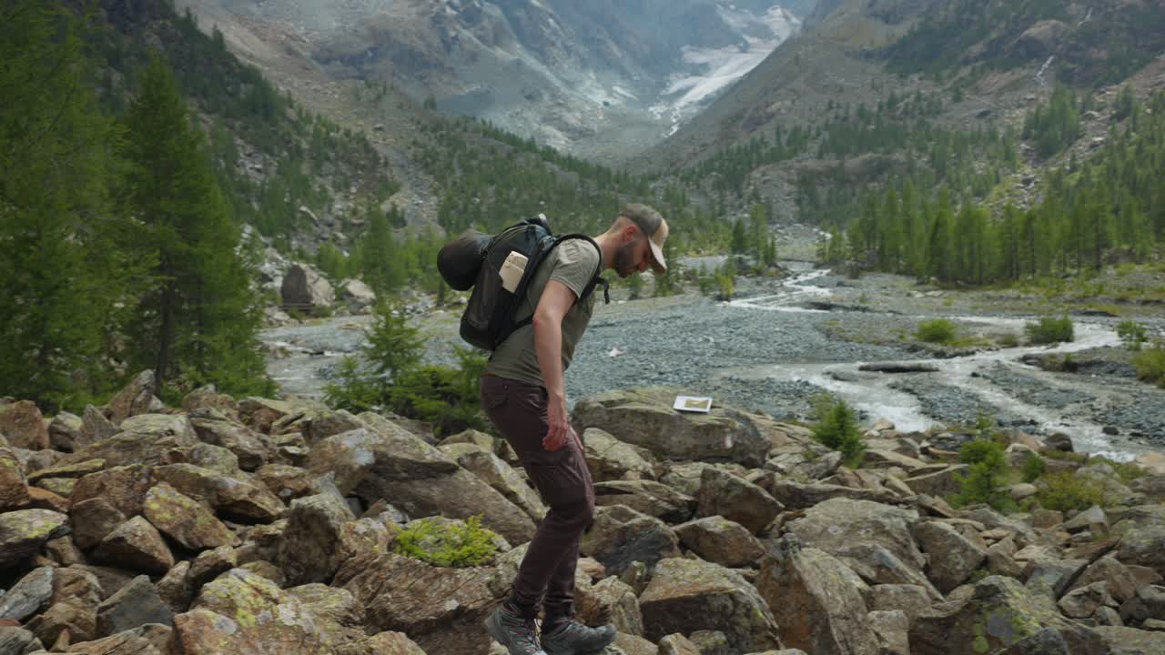 el mochilero caucásico conquista el sendero rocoso de la montaña bajo un cielo nublado.
