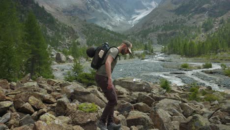 Caucasian-backpacker-conquers-rocky-mountain-path-under-cloudy-skies