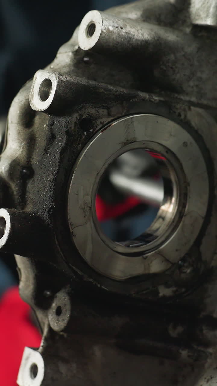 primer plano de un motor trabajado por un mecánico con guantes rojos, centrándose en las piezas y herramientas intrincadas involucradas en el proceso de mantenimiento