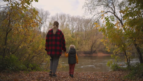 Geheimer-See-Im-Wald,-Mutter-Und-Kleiner-Sohn-Gehen-Am-Herbsttag-Am-Ufer-Spazieren,-Gute-Erinnerungen-An-Die-Kindheit,-Glückliche-Elternschaft