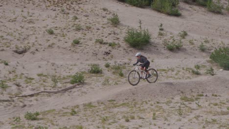 Un-Ciclista-De-Montaña-Viaja-Por-Un-Camino-De-Tierra-Cerca-De-Un-Bosque.