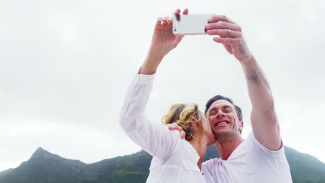 pareja madura tomando una selfie en la playa