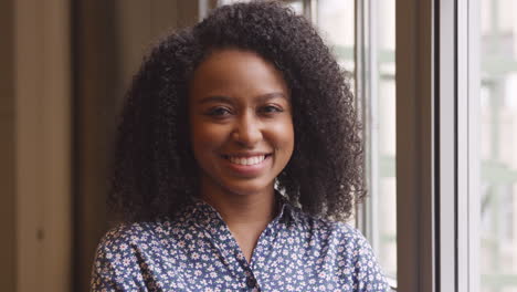 Casually-dressed-young-black-businesswoman-smiling-to-camera