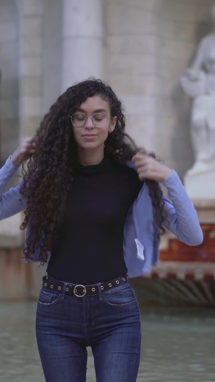 Young woman posing outdoors near a fountain