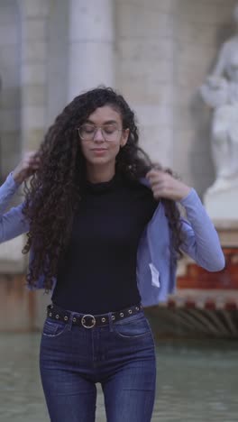 young woman posing outdoors near a fountain