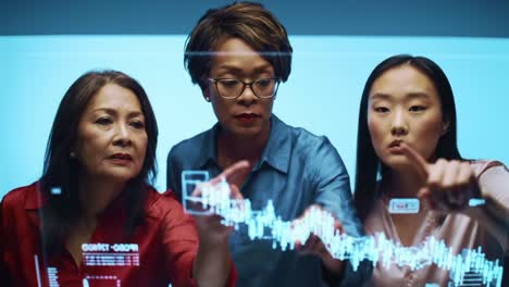 three professionals analyzing data trends with interactive graphs, collaborating with technology for insights and understanding in a modern workspace