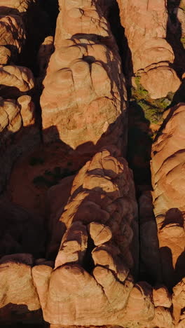 group of rock formations with rounded tops from aerial erosion. sunlit canyons of arches national park from top view. vertical video