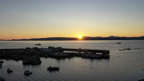 Eine-Beeindruckende-Sonnenuntergangs-drohnenaufnahme-Von-Mallaig,-Schottland,-Die-Die-Stadt-Und-Die-Isle-Of-Skye-In-Der-Ferne-Zeigt