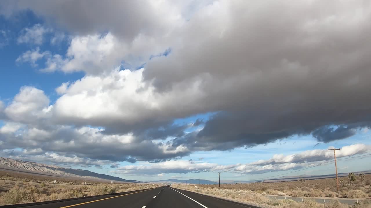 placa de proceso de conducción a través de la carretera del desierto de mojave en un día nublado, timelapse