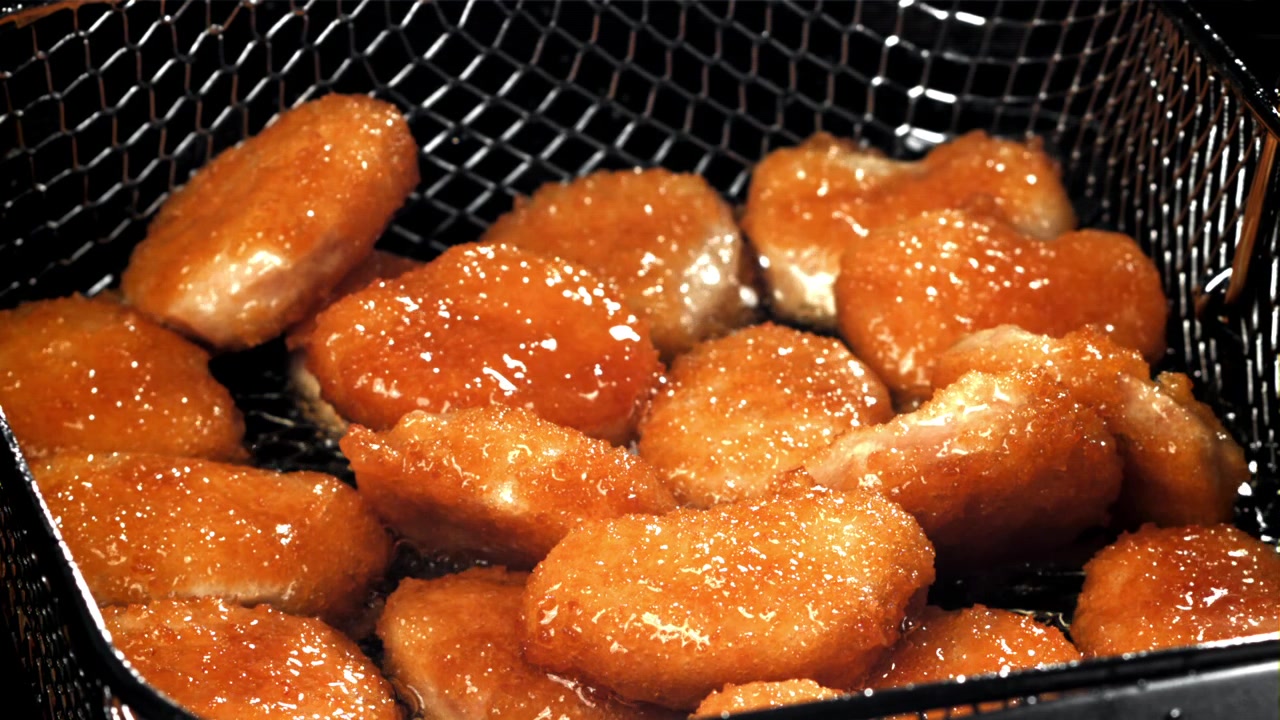 Primo piano di nuggets fritti croccanti in un cestello della friggitrice