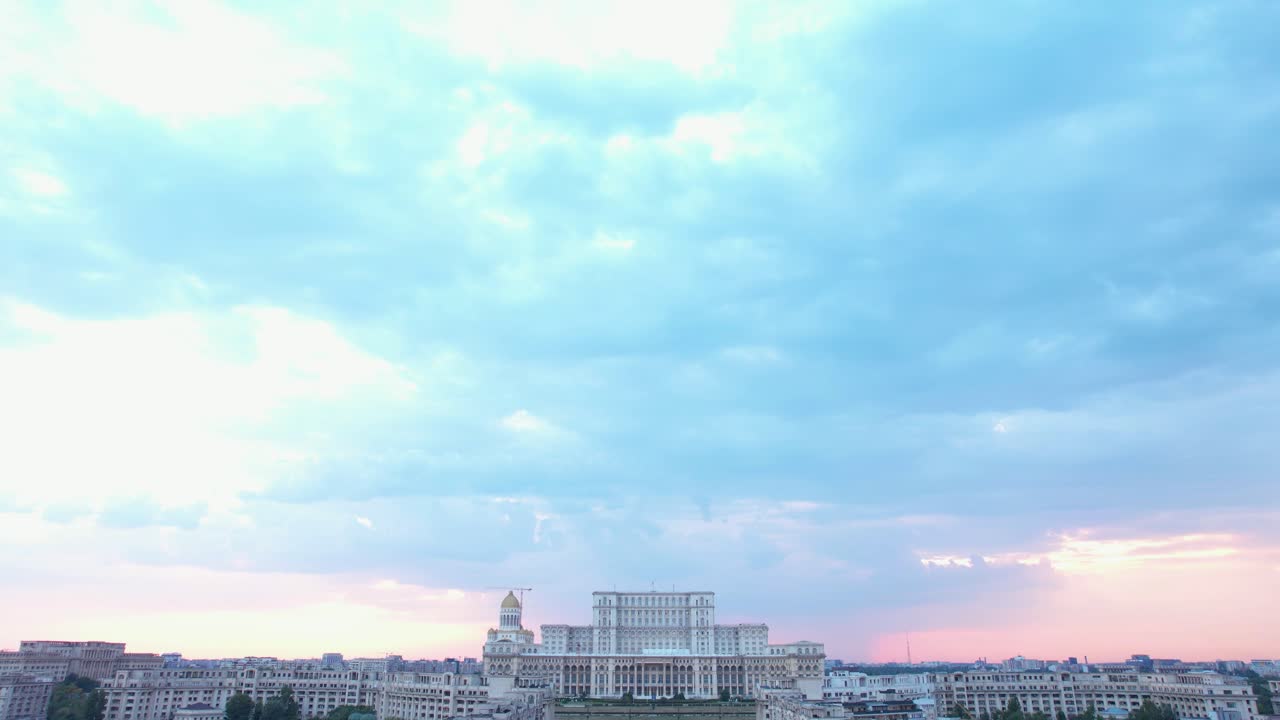 lenta revelación hacia abajo del palacio del parlamento en bucarest, rumania con un cielo naranja en el fondo al atardecer