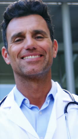 un médico sonriente de pie en el hospital