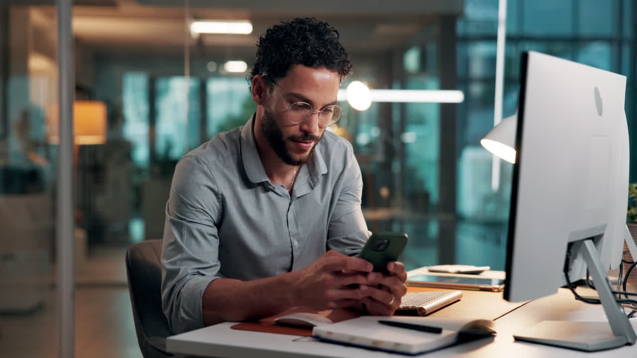 Young Man Using Smartphone at Desk in Modern Office