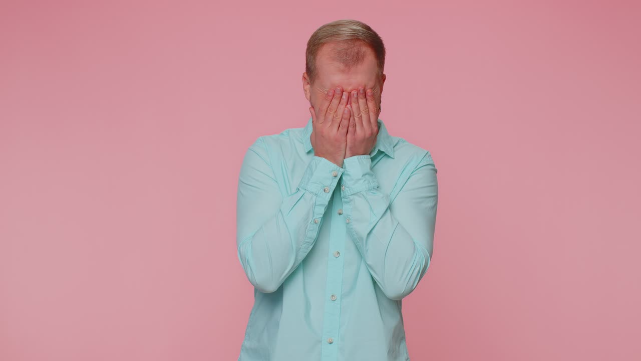 Upset disappointed man alone wipes tears and cries from despair being sad because of unfair things