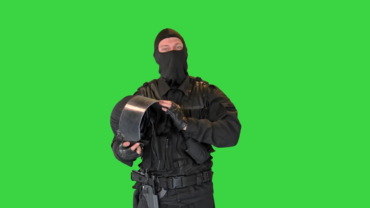 Special police unit taking helmet off on a Green Screen, Chroma Key