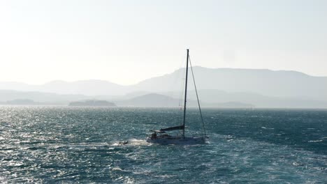 Velero-Navegando-Por-Las-Turbulentas-Aguas-Del-Mar-Jónico-Cerca-De-La-Isla-De-Corfú,-Remolcando-Un-Pontón