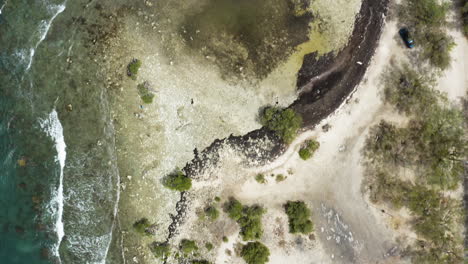 AERIAL---Boats-on-the-beach,-Monte-Rio,-Dominican-Republic,-top-down-reverse-shot