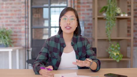 happy asian businesswoman talking and waving during casual work video call, slow motion, copy space