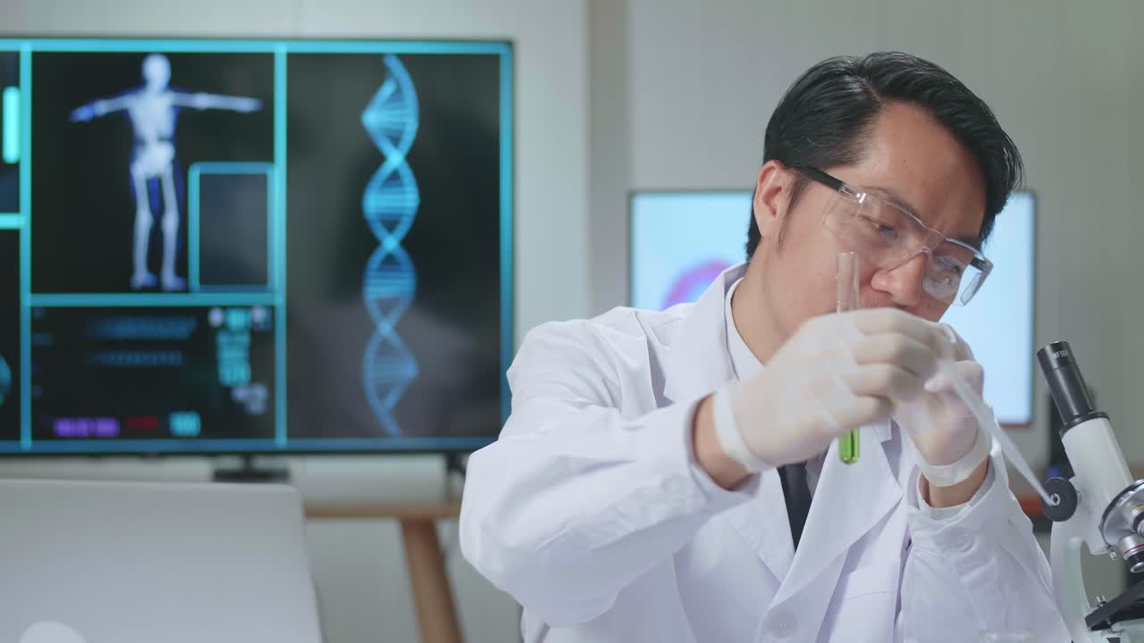 Young Asian Male Research Scientist Holding Glass Test Tube And Speaking To The Camera