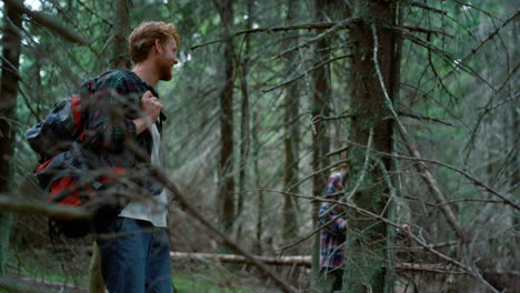 una mujer y un hombre sonrientes caminando juntos por el bosque.